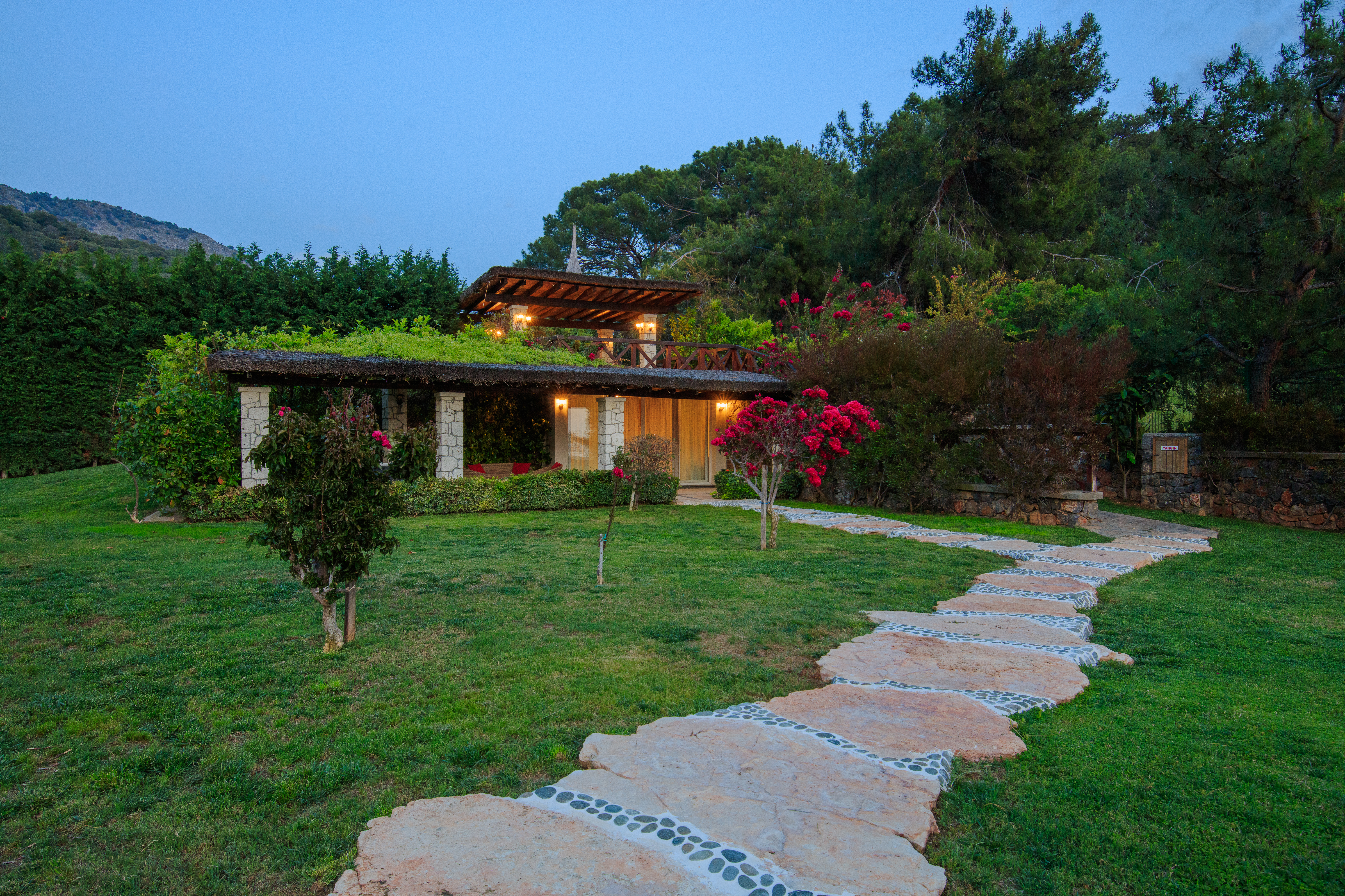 Villa gokce stone facade garden path evening